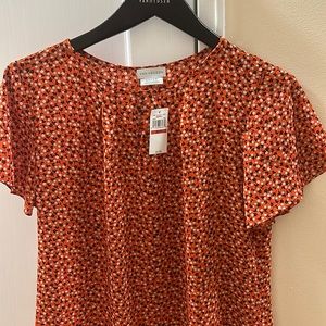 Spring floral blouse with light green and white flowers and orange background